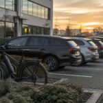 Budget mobilité et voiture de société : parking d'entreprise avec voitures et vélo