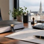 Créer une SRL en Belgique : statuts de société reliés et un reçu notarié posés sur un bureau à côté d'une calculatrice