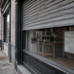 Faillite d'entreprise : vitrine fermée d'un commerce belge