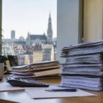 Finances publiques belges : pile de documents fiscaux sur un bureau