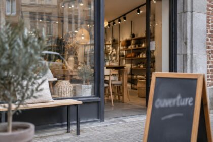 Seconde chance après faillite : vitrine d'un commerce belge rouvert avec un panneau flouté « ouverture » et du mobilier neuf visible